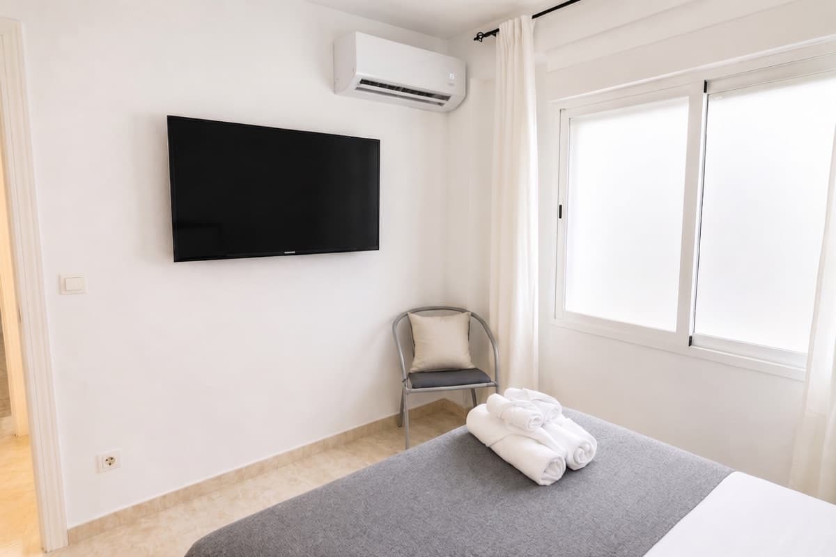 Bedroom with air conditioning and wall-mounted smart TV